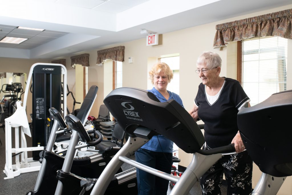 Avila's Fitness Rehab Specialist working with a resident in the fitness center