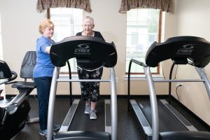 rehab specialist with resident on treadmill