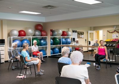residents with trainer in chair exercise class