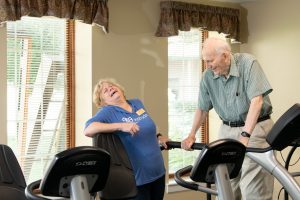 fitness specialist with resident on treadmill