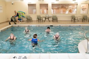 residents exercising in pool on hydro riders